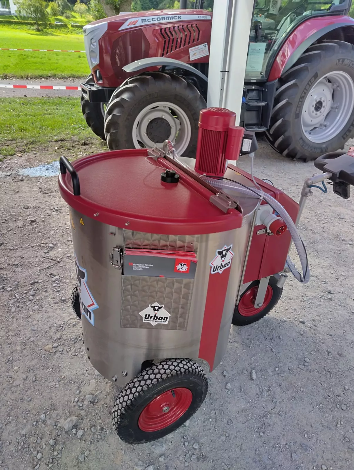 Urban Fütterungstechnik-Gerät vor einem McCormick Traktor